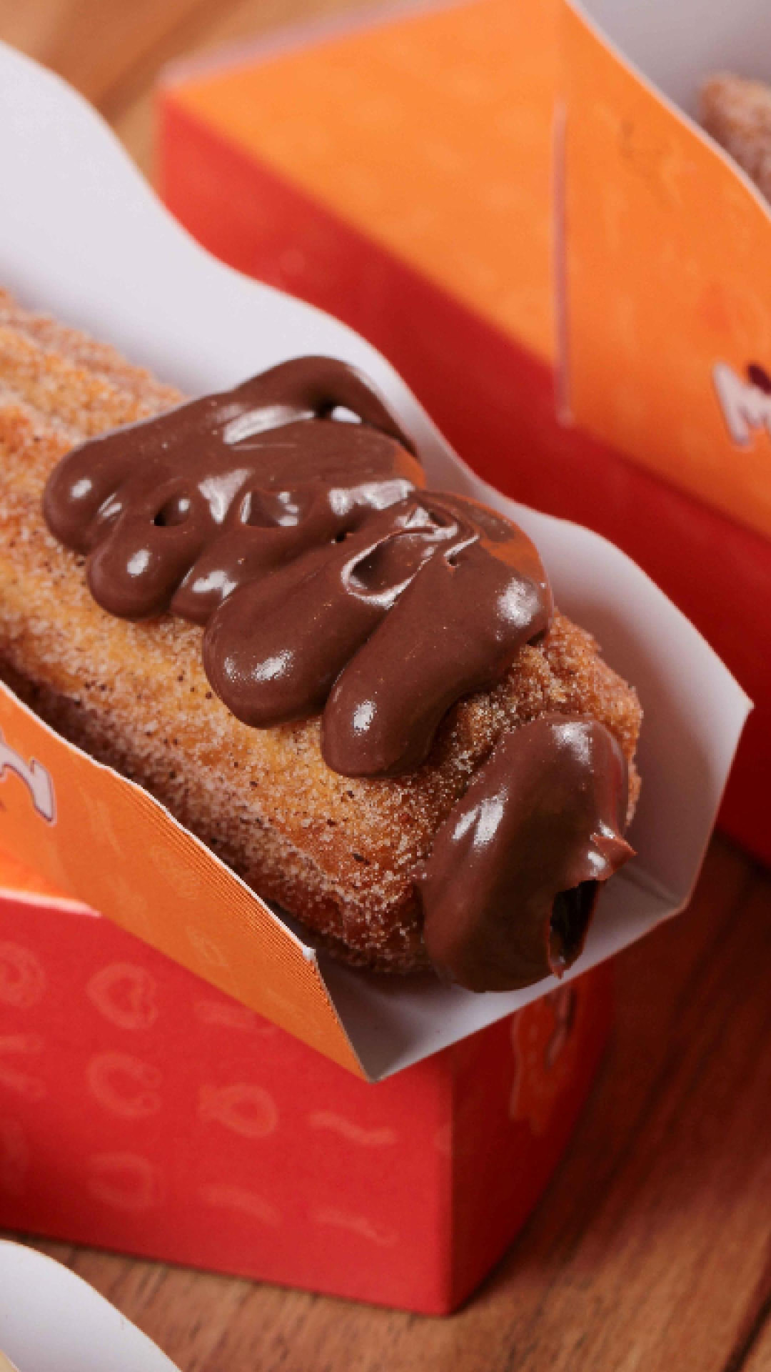 Churros gourmet coberto com creme de chocolate na embalagem da Maneluh