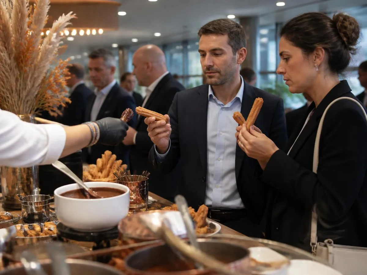 Convidados de traje social provando churros em evento de empresa em ambiente moderno